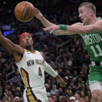 
              Boston Celtics guard Payton Pritchard (11) passes the ball while pressured by New Orleans Pelicans guard Devonte' Graham (4) during the second half of an NBA basketball game, Wednesday, Jan. 11, 2023, in Boston. (AP Photo/Charles Krupa)
            
