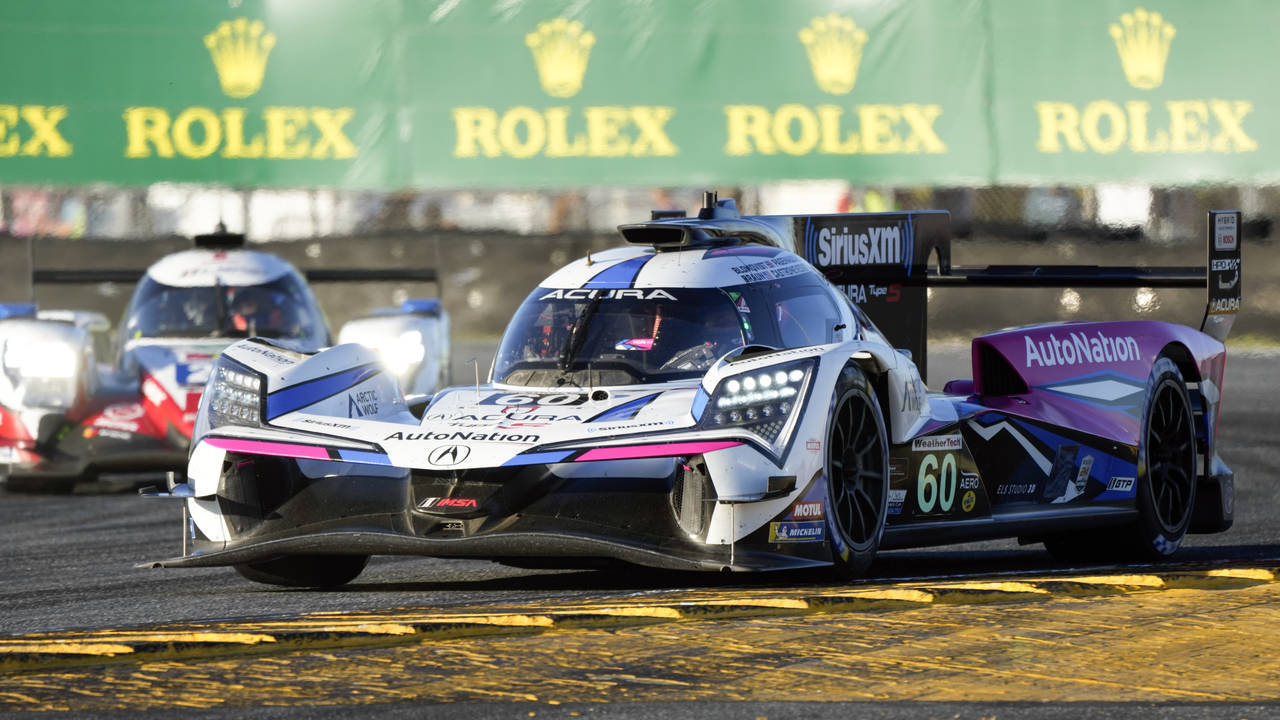 The Meyer Shank Racing Acura ARX-06 passes the High Class Racing ORECA LMP2 07 in a turn during a p...