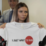 
              FILE - Belarusian Olympic sprinter Krystsina Tsimanouskaya, who arrived in Poland fearing reprisals at home after criticizing her coaches at the Tokyo Games, holds up an Olympic-related T-shirt with the slogan "I Just Want to Run" after her news conference in Warsaw, Poland, Thursday, Aug. 5, 2021. The Belarusian track coach who tried to force the sprinter out of the Tokyo Olympics and back to Belarus after she was critical of the team has been charged with breaching the sport's integrity standards. The Athletics Integrity Unit announced the charges against Yury Maisevich on Thursday, Jan. 19, 2023. (AP Photo/Czarek Sokolowski, File)
            