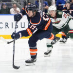 
              New York Islanders' Matt Martin (17) shoots the puck as Minnesota Wild's Jonas Brodin (25) chases him during the second period of an NHL hockey game Thursday, Jan. 12, 2023, in Elmont, N.Y. (AP Photo/Frank Franklin II)
            