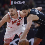 
              Brooklyn Nets' Ben Simmons (10) reaches for the ball next to Chicago Bulls' Nikola Vucevic (9) during the first half of an NBA basketball game Wednesday, Jan. 4, 2023, in Chicago. (AP Photo/Paul Beaty)
            