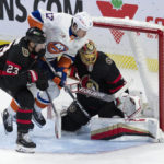 
              New York Islanders left wing Matt Martin jumps through the crease between Ottawa Senators defenseman Travis Hamonic and goaltender Anton Forsberg as he chases the puck during the third period of an NHL hockey game, Wednesday, Jan. 25, 2023 in Ottawa, Ontario. (Adrian Wyld/The Canadian Press via AP)
            