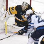 
              Winnipeg Jets center Kevin Stenlund (28) can't get off a shot in front of Pittsburgh Penguins goaltender Dustin Tokarski (40) during the first period of an NHL hockey game in Pittsburgh, Friday, Jan. 13, 2023. (AP Photo/Gene J. Puskar)
            