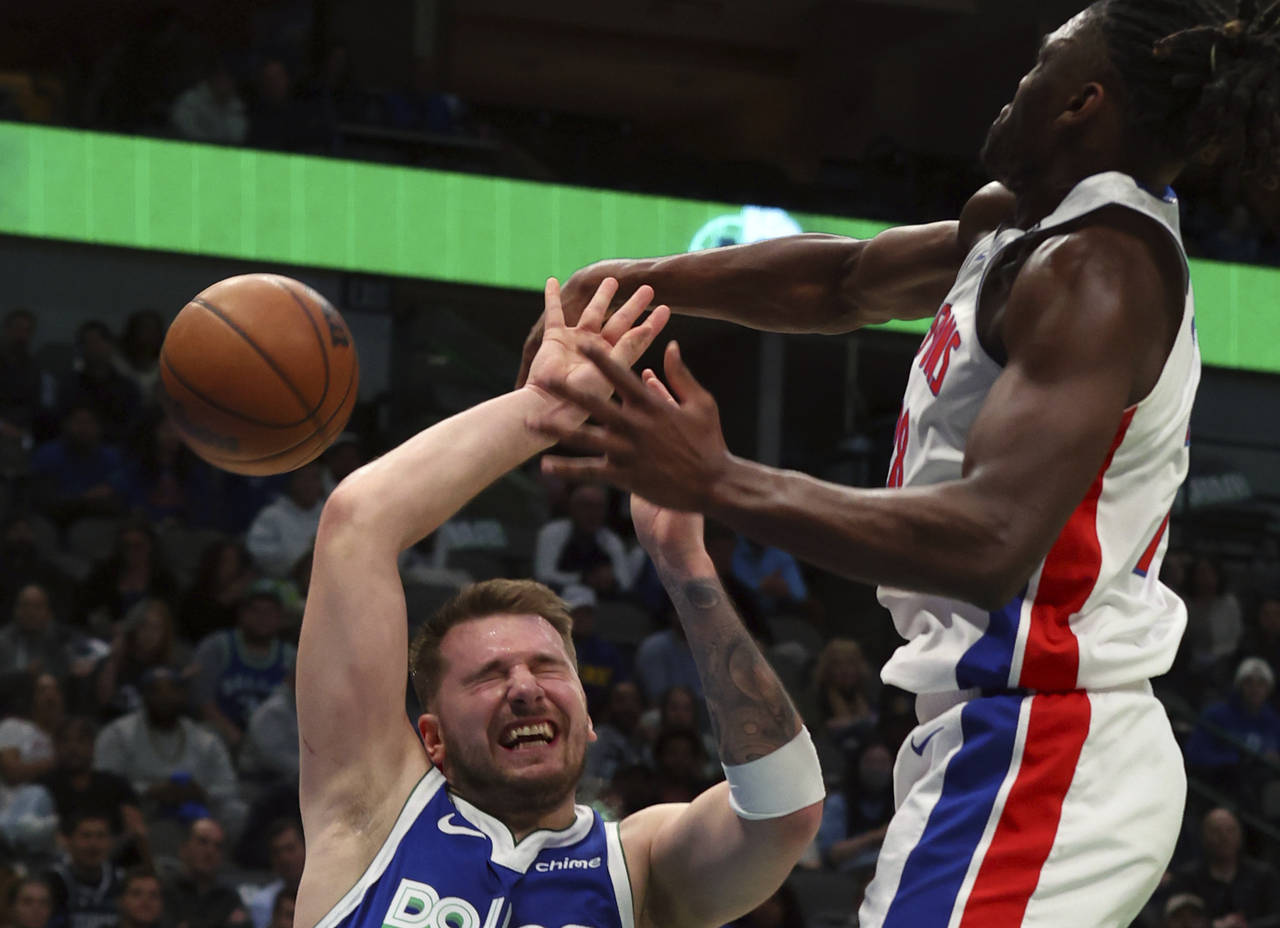 Dallas Mavericks guard Luka Doncic, left, is fouled by Detroit Pistons center Isaiah Stewart, right...