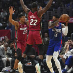 
              Los Angeles Clippers guard Paul George (13) looks to pass the ball against Miami Heat center Orlando Robinson (25) and forward Jimmy Butler (22) during the first half of an NBA basketball game Monday, Jan. 2, 2023, in Los Angeles. (AP Photo/Allison Dinner)
            