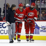 
              Carolina Hurricanes head athletic trainer Doug Bennett, left, and Brent Burns, right, assist Max Pacioretty off the ice following an injury during the third period of the team's NHL hockey game against the Minnesota Wild in Raleigh, N.C., Thursday, Jan. 19, 2023. (AP Photo/Karl B DeBlaker)
            