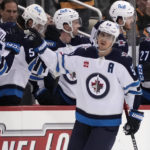 
              Winnipeg Jets' Mark Scheifele (55) returns to the bench after scoring against the Pittsburgh Penguins during the second period of an NHL hockey game in Pittsburgh, Friday, Jan. 13, 2023. (AP Photo/Gene J. Puskar)
            