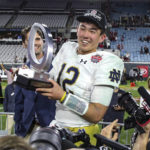 
              Notre Dame quarterback Tyler Buchner (12) holds with the MVP trophy after the team's Gator Bowl NCAA college football game against South Carolina on Friday, Dec. 30, 2022, in Jacksonville, Fla. Notre Dame won 45-38. (AP Photo/Gary McCullough)
            