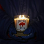 
              FILE - A person holds a Buffalo Bills candle during a a candlelight vigil for Bills safety Damar Hamlin on Tuesday, Jan. 3, 2023, in Orchard Park, N.Y. The Buffalo Bills have been a reliable bright spot for a city that has been shaken by a racist mass shooting and back-to-back snowstorms in recent months. So when Bills safety Damar Hamlin was critically hurt in a game Monday, the city quickly looked for ways to support the team. (AP Photo/Joshua Bessex, File)
            