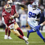 
              San Francisco 49ers quarterback Brock Purdy (13) runs against Dallas Cowboys defensive end Dorance Armstrong (92) during the second half of an NFL divisional round playoff football game in Santa Clara, Calif., Sunday, Jan. 22, 2023. (AP Photo/Tony Avelar)
            