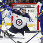 
              Winnipeg Jets goaltender Connor Hellebuyck (37) makes a save in traffic during the first period of an NHL hockey game against the Buffalo Sabres, Thursday, Jan. 12, 2023, in Buffalo, N.Y. (AP Photo/Jeffrey T. Barnes)
            