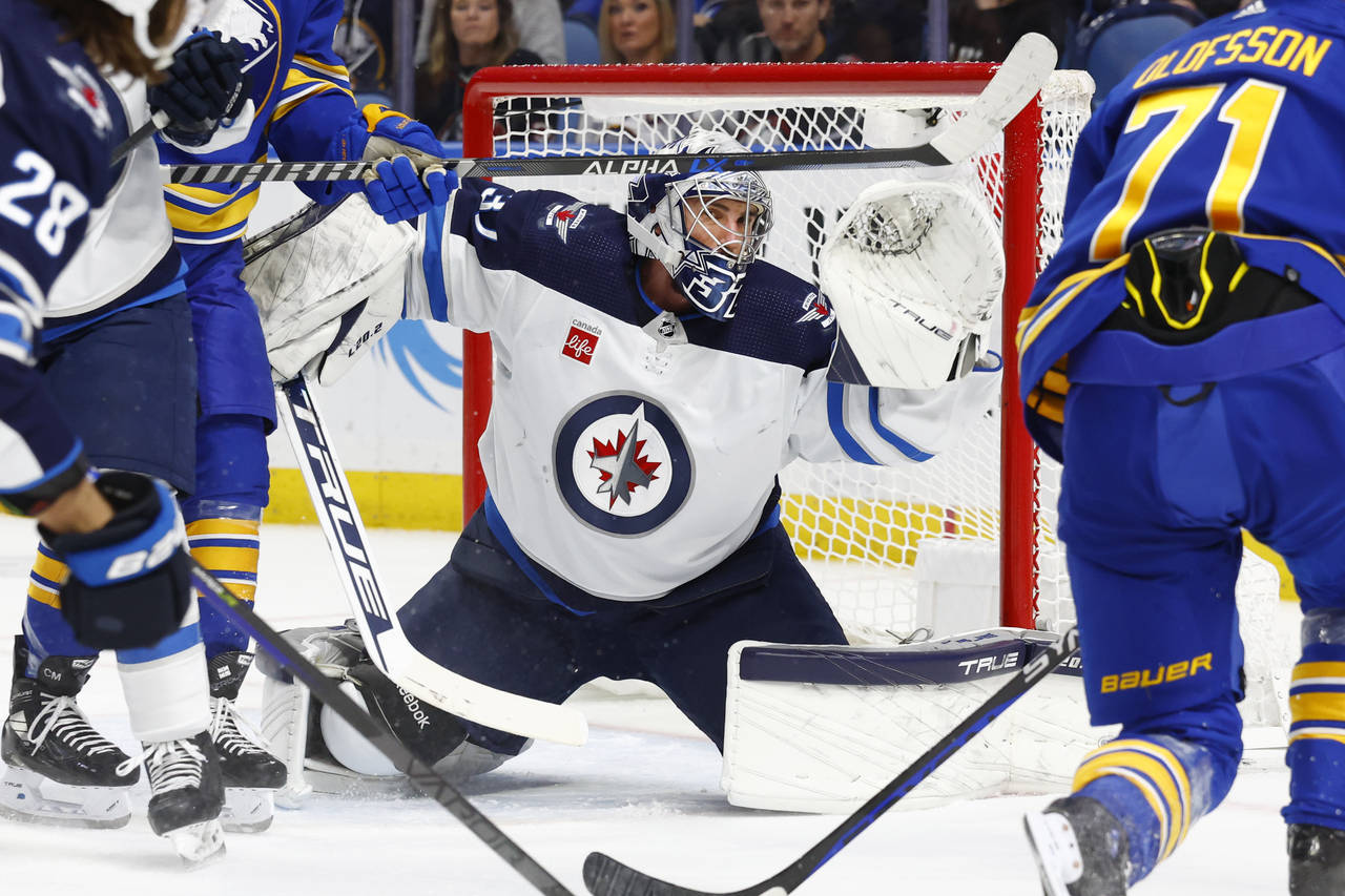 Winnipeg Jets goaltender Connor Hellebuyck (37) makes a save in traffic during the first period of ...