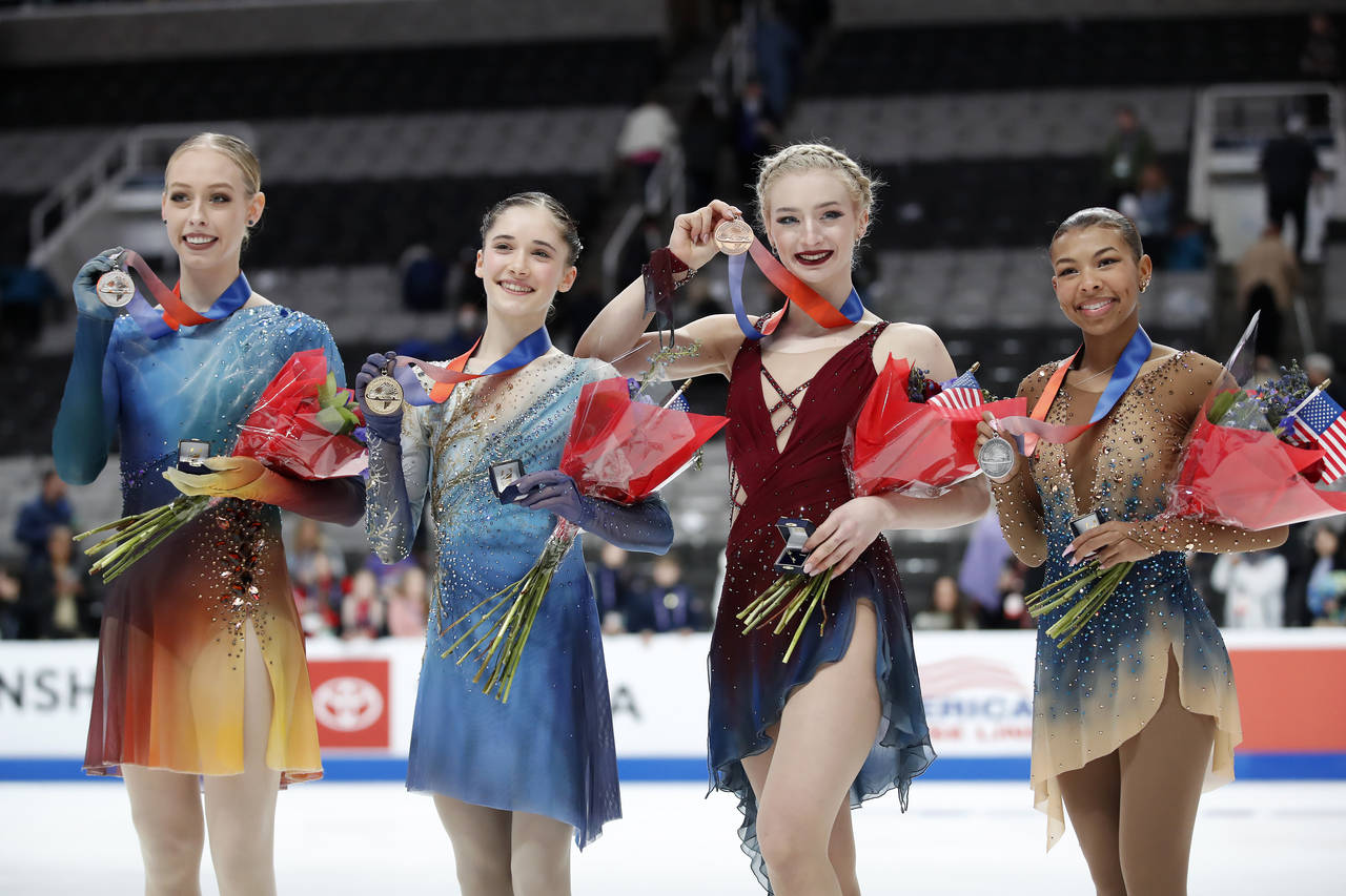 Bradie Tennell, Isabeau Levito, Amber Glenn and Starr Andrews, from left, hold up their medals afte...