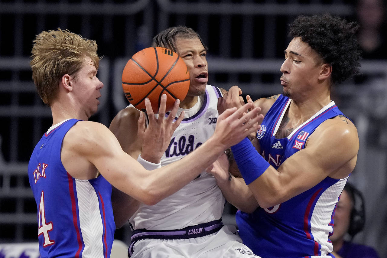 Kansas guard Gradey Dick (4) and forward Jalen Wilson, right, try to steal the ball from Kansas Sta...