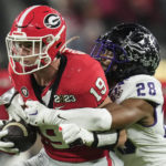 
              TCU safety Millard Bradford (28) tackles Georgia tight end Brock Bowers (19) during the first half of the national championship NCAA College Football Playoff game, Monday, Jan. 9, 2023, in Inglewood, Calif. (AP Photo/Ashley Landis)
            