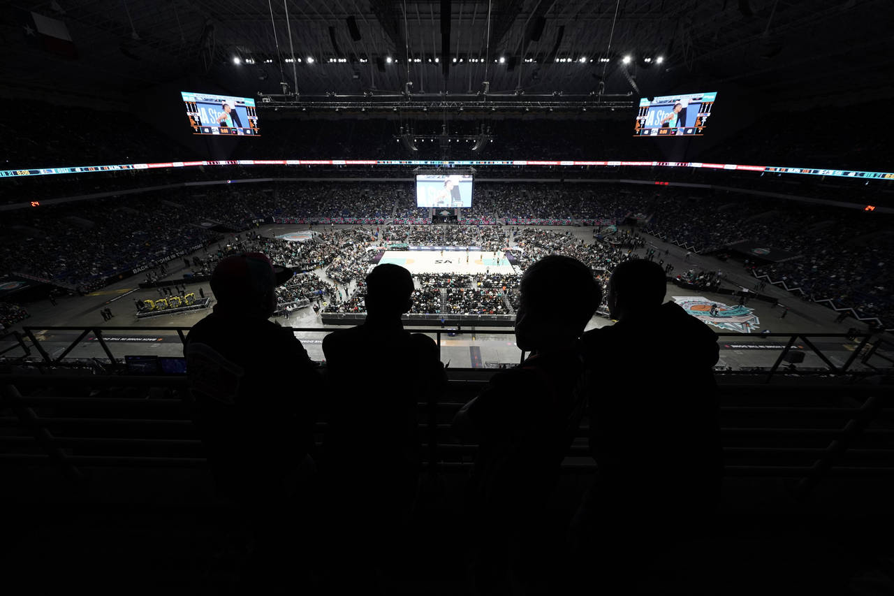 Fans watch the first half of an NBA basketball game between the San Antonio Spurs and the Golden St...