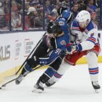 
              Columbus Blue Jackets' Kent Johnson, left, and New York Rangers' Jacob Trouba fight for a loose puck during the second period of an NHL hockey game on Monday, Jan. 16, 2023, in Columbus, Ohio. (AP Photo/Jay LaPrete)
            
