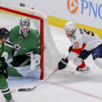 
              Florida Panthers center Sam Bennett (9) attempts a shot between Dallas Stars center Radek Faksa (12) and goalie Jake Oettinger, center, in the third period of an NHL hockey game in Dallas, Sunday, Jan. 8, 2023. (AP Photo/Gareth Patterson)
            