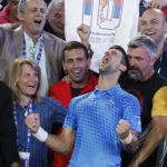 
              Novak Djokovic of Serbia, center, celebrates with his team including his mother, Dijana, left, after defeating Stefanos Tsitsipas of Greece in the men's singles final at the Australian Open tennis championships in Melbourne, Australia, Sunday, Jan. 29, 2023. (AP Photo/Asanka Brendon Ratnayake)
            