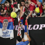 
              Novak Djokovic of Serbia signs autographs after defeating Roberto Carballes Baena of Spain in their first round match at the Australian Open tennis championship in Melbourne, Australia, Wednesday, Jan. 18, 2023. (AP Photo/Aaron Favila)
            