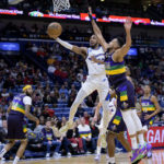 
              Washington Wizards guard Monte Morris (22) shoots against New Orleans Pelicans guard CJ McCollum (3) in the first half of an NBA basketball game in New Orleans, Saturday, Jan. 28, 2023. (AP Photo/Matthew Hinton)
            