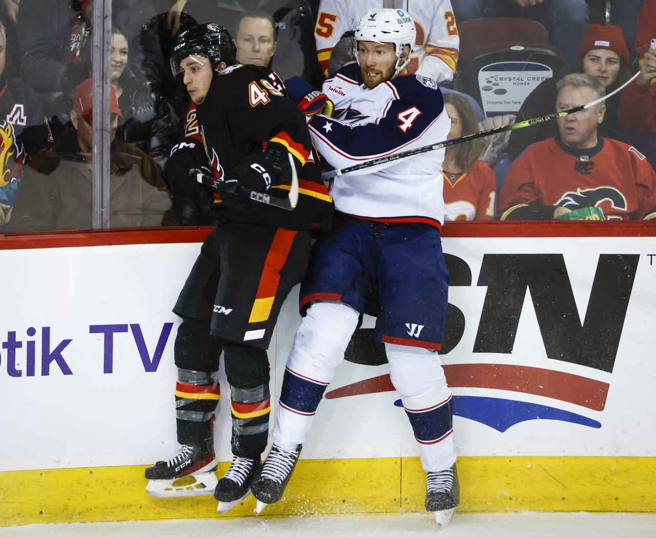 Calgary Flames forward Andrew Mangiapane, left, is checked by
