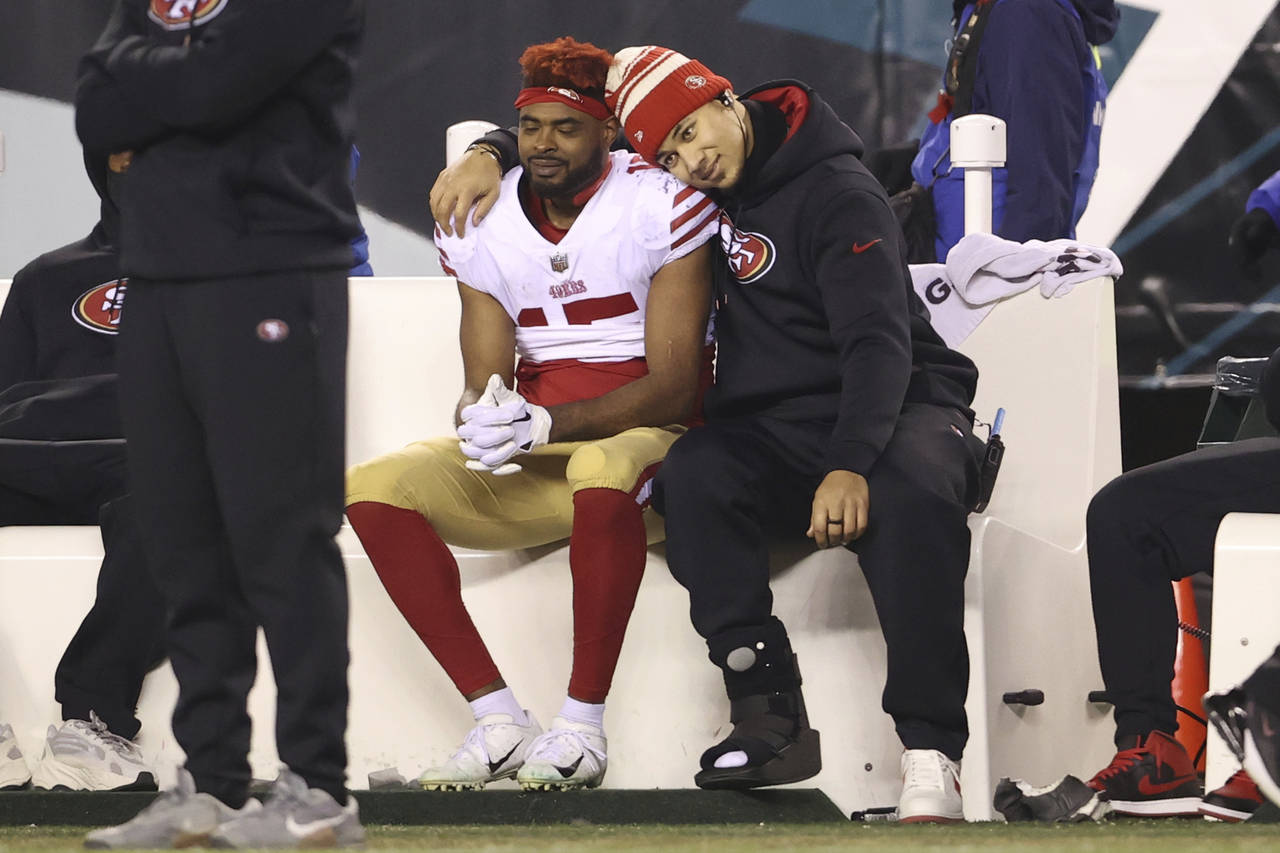San Francisco 49ers' Jauan Jennings, left, and Trey Lance embrace on the bench in the final minute ...