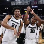 
              Providence guard Noah Locke (10) and forward Clifton Moore (21) celebrate the team's win over UConn in an NCAA college basketball game, Wednesday, Jan. 4, 2023, in Providence, R.I. Providence won 73-61. (AP Photo/Charles Krupa)
            