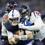 
              Indianapolis Colts quarterback Sam Ehlinger is sacked by Houston Texans safety Jonathan Owens (36) and defensive end Jonathan Greenard during the first half of an NFL football game between the Houston Texans and Indianapolis Colts, Sunday, Jan. 8, 2023, in Indianapolis. (AP Photo/AJ Mast)
            