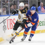 
              Boston Bruins' Trent Frederic (11) fights for control of the puck with New York Islanders' Anthony Beauvillier (18) during the first period of an NHL hockey game Wednesday, Jan. 18, 2023, in Elmont, N.Y. (AP Photo/Frank Franklin II)
            