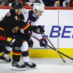
              Columbus Blue Jackets forward Johnny Gaudreau, right, is checked by Calgary Flames forward Mikael Backlund during second-period NHL hockey game action in Calgary, Alberta, Monday, Jan. 23, 2023. (Jeff McIntosh/The Canadian Press via AP)
            