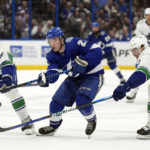 
              Tampa Bay Lightning center Brayden Point (21) slips between Vancouver Canucks center Bo Horvat (53) and defenseman Luke Schenn (2) during the second period of an NHL hockey game Thursday, Jan. 12, 2023, in Tampa, Fla. (AP Photo/Chris O'Meara)
            