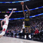 
              Golden State Warriors forward Andrew Wiggins, right, shoots over Chicago Bulls guard Alex Caruso during the first half of an NBA basketball game in Chicago, Sunday, Jan. 15, 2023. (AP Photo/Nam Y. Huh)
            