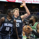 
              Boston Celtics guard Jaylen Brown, right, looks for a shot against Orlando Magic's Bol Bol (10) and Moritz Wagner (21) during the first half of an NBA basketball game, Monday, Jan. 23, 2023, in Orlando, Fla. (AP Photo/John Raoux)
            