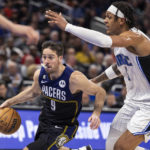 
              Indiana Pacers guard T.J. McConnell (9) drives against Orlando Magic forward Paolo Banchero (5) during the first half of an NBA basketball game Wednesday, Jan. 25, 2023, in Orlando, Fla. (AP Photo/Kevin Kolczynski)
            
