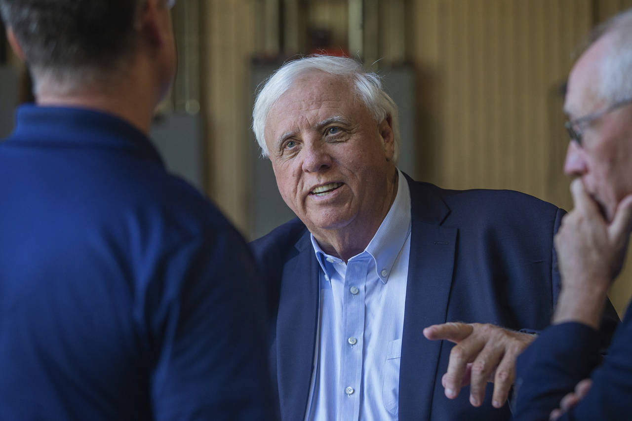 FILE - Gov. Jim Justice, center, speaks to Merl Wooten, owner of Wooten Machine Co., left, and Dr. ...