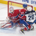 
              Winnipeg Jets' Karson Kuhlman (20) is held up by Montreal Canadiens' Jordan Harris (54) as he moves in on Canadiens goaltender Sam Montembeault during the first period of an NHL hockey game, Tuesday, Jan. 17, 2023 in Montreal. (Graham Hughes/The Canadian Press via AP)
            