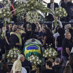 
              People pay their last respects to the late Brazilian soccer great Pele whose lies in state at Vila Belmiro stadium in Santos, Brazil, Monday, Jan. 2, 2023. (AP Photo/Marcelo Chello)
            