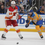 
              Calgary Flames' Elias Lindholm (28) and St. Louis Blues' Calle Rosen (43) chase after a loose puck during the second period of an NHL hockey game Tuesday, Jan. 10, 2023, in St. Louis. (AP Photo/Jeff Roberson)
            