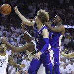 
              Kansas guard Gradey Dick (4), Kansas guard Joseph Yesufu (1) and Baylor forward Flo Thamba, second from left, reach for the ball during the second half of an NCAA college basketball game Monday, Jan. 23, 2023, in Waco, Texas. (AP Photo/Jerry Larson)
            