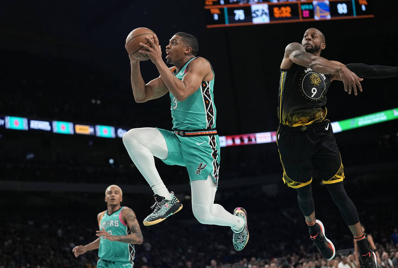 San Antonio Spurs forward Keldon Johnson (3) drives to the basket past Golden State Warriors forwar...