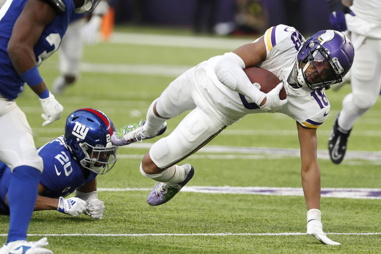 Minnesota Vikings wide receiver Justin Jefferson (18) is tackled by New York Giants safety Julian L...