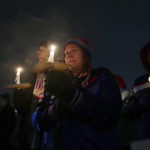 
              FILE - Curtis, left, and Amanda Grantham listen to speakers during a candlelight vigil for Buffalo Bills safety Damar Hamlin on Tuesday, Jan. 3, 2023, in Orchard Park, N.Y. The Buffalo Bills have been a reliable bright spot for a city that has been shaken by a racist mass shooting and back-to-back snowstorms in recent months. So when Bills safety Damar Hamlin was critically hurt in a game Monday, the city quickly looked for ways to support the team. (AP Photo/Joshua Bessex)
            