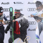
              Slovenia's Ilka Stuhec, right, winner of an alpine ski, women's World Cup downhill race, celebrates on the podium with second-placed Norway's Kajsa Vickhoff Lie, left, as former World Cup alpine skier Alberto Tomba stands behind, in Cortina d'Ampezzo, Italy, Saturday, Jan. 21, 2023. (AP Photo/Alessandro Trovati)
            