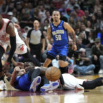
              Miami Heat center Bam Adebayo (13), Orlando Magic guard Jalen Suggs, center, and guard Victor Oladipo, right, go for a loose ball during the first half of an NBA basketball game, Friday, Jan. 27, 2023, in Miami. (AP Photo/Lynne Sladky)
            