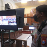 
              A police officer stands guard inside a court room before a trial in Surabaya, East Java, Indonesia, Monday, Jan, 16, 2023. The court began a trial Monday against five men on charges of negligence leading to deaths of 135 people after police fired tear gas inside a soccer stadium, setting off a panicked run for the exits in which many were crushed. (AP Photo/Trisnadi)
            