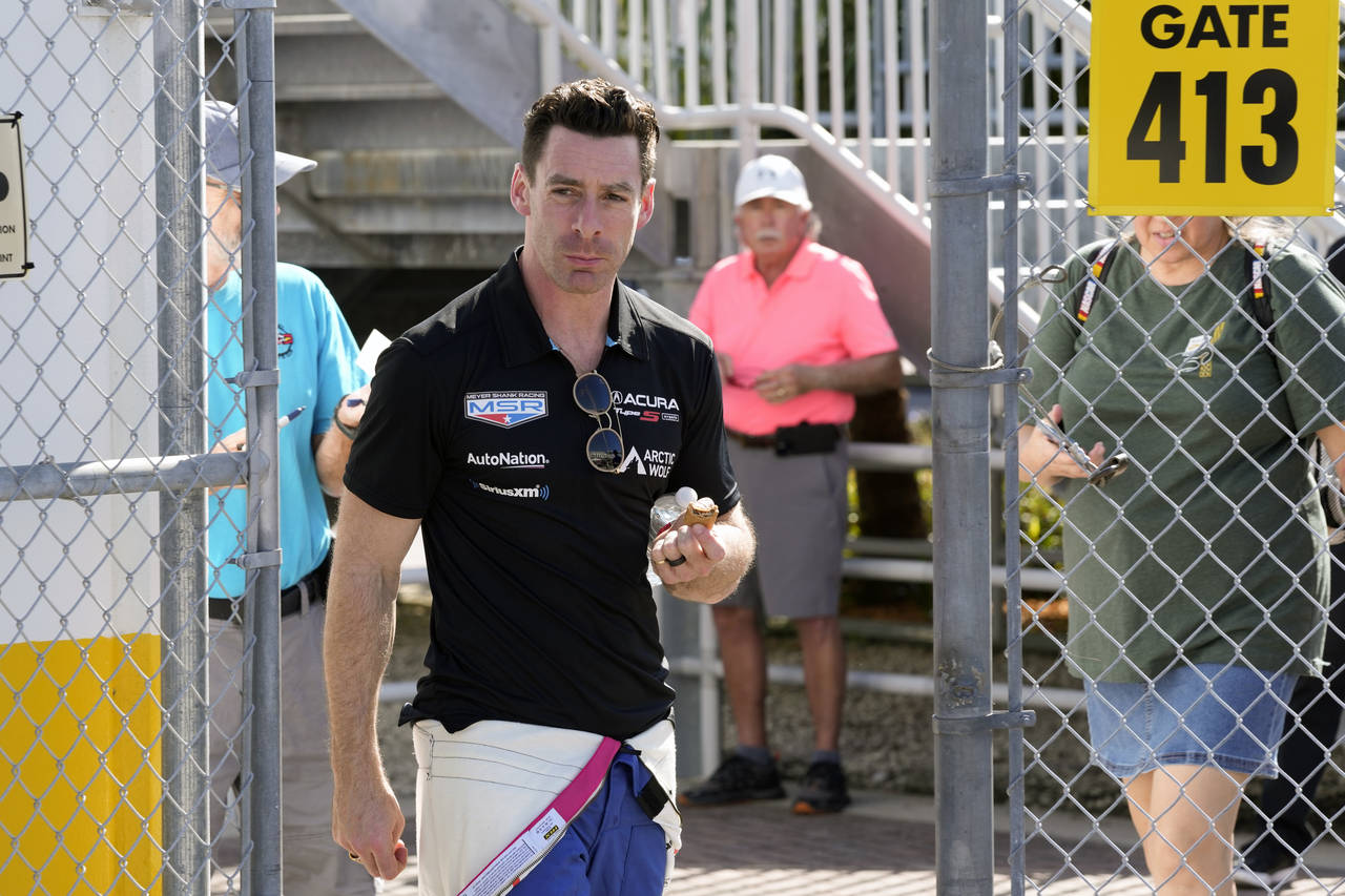 Simon Pagenaud, of France, walks to his garage during auto race testing for the upcoming Rolex 24 h...