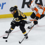 
              Boston Bruins left wing Brad Marchand controls the puck ahead of Philadelphia Flyers defenseman Rasmus Ristolainen (55) during the first period of an NHL hockey game, Monday, Jan. 16, 2023, in Boston. (AP Photo/Mary Schwalm)
            