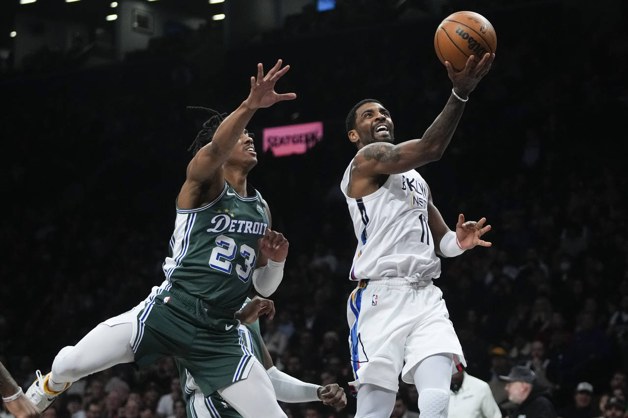 Brooklyn Nets' Kyrie Irving, right, drives past Detroit Pistons' Jaden Ivey during the first half o...