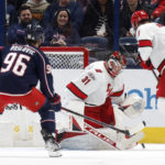 
              Carolina Hurricanes goalie Frederik Andersen, center, makes a stop between Columbus Blue Jackets forward Jack Roslovic, left, and Hurricanes defenseman Brent Burns during the first period of an NHL hockey game in Columbus, Ohio, Thursday, Jan. 12, 2023. (AP Photo/Paul Vernon)
            